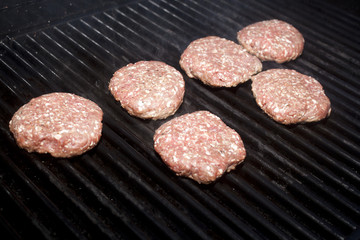 Hamburger patties cooking on a grill
