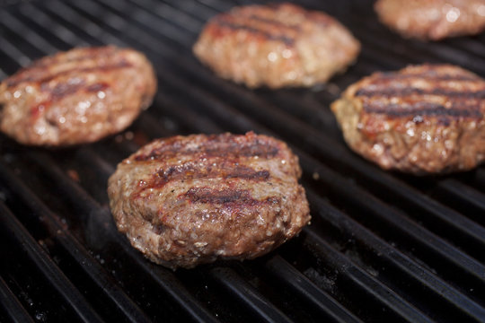 Hamburger patties cooking on a grill