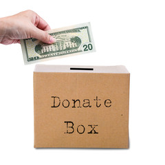 Human hand putting money in brown donate box. Concept of savings