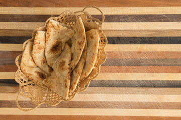 Deliciously baked naan flatbread slices in basket