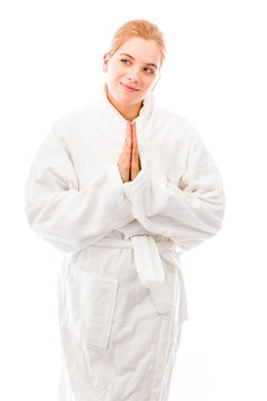 Young woman standing in bathrobe in prayer position