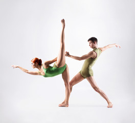 Couple of gymnasts training in a studio