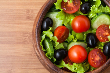 Salad on wooden plate.