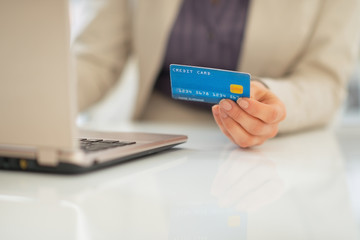 Closeup on business woman credit card using laptop