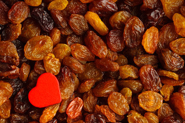 Diet healthy food. Raisin as background texture and red heart