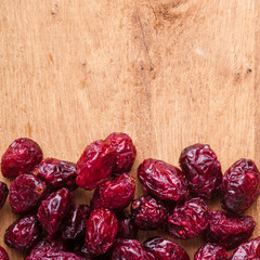 Diet and food. Border of dried cranberries on wooden background