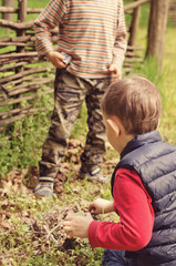 Two young boys discussing lighting a campfire