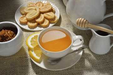 Cup of tea with lemon and cookies on table