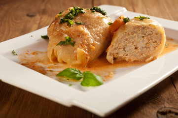 Closeup of stuffed cabbage rolls with tomato souce and herbs