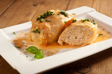 Closeup of stuffed cabbage rolls with tomato souce and herbs