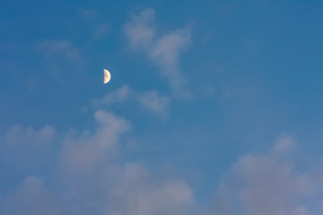 Moon on blue sky with pink clouds