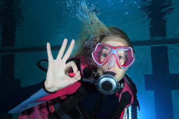 Female scuba diver show underwater signal