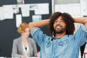 mann im büro lehnt sich entspannt zurück