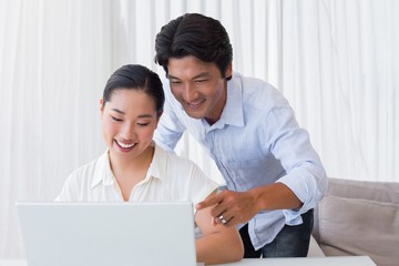 Happy couple using laptop together