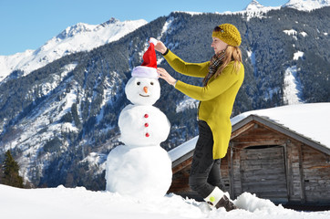 Girl decorating a snowman