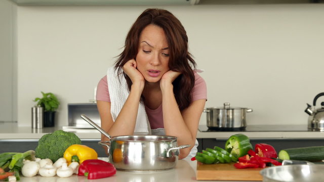 Puzzled woman looking down at her saucepan