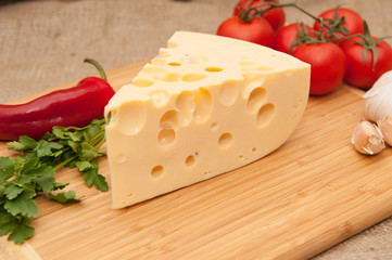 cheese and vegetables on wooden board