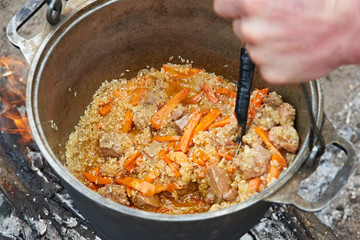 Cooking pilaf on campfire