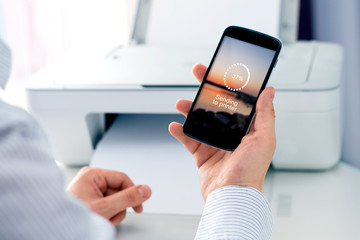 Man sending a photo to wireless printer. Cloud print concept