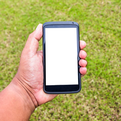 mobile on hand with green grass in garden