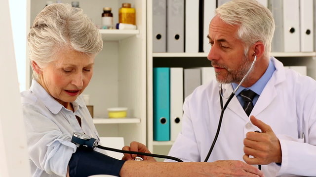 Doctor taking blood pressure of his patient