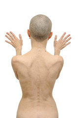 Naked woman standing with palms on the wall