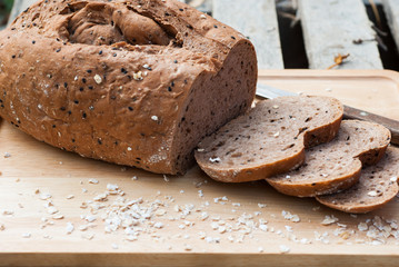 Several slices of Bread wheat and wooden chopping board