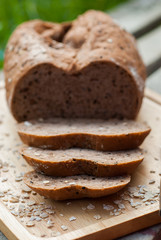 Several slices of Bread wheat and wooden chopping board