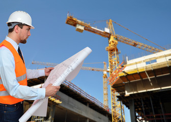 Architekt mit Plan auf Baustelle