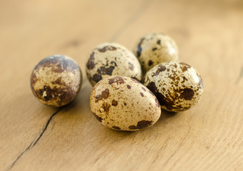 Obraz premium Few quail eggs on wooden tabletop.