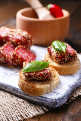 Composition with knife,  tasty sandwiches with salami sausage,
