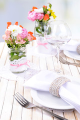 Beautiful table setting with spring flowers in jar close-up