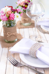 Beautiful table setting with spring flowers in jar close-up