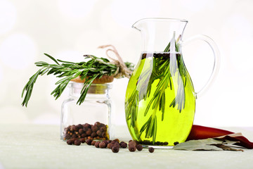 Essential Oil with rosemary in glass jug, isolated on white