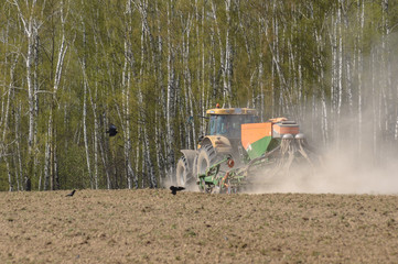 The tractor is engaged in the sowing of cereal crops in the fiel