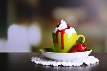 Cup of coffee with cream and strawberry sauce