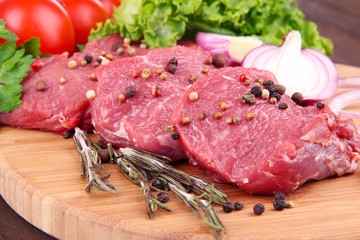 Raw beef meat with vegetables on table close up
