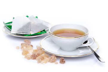 A cup of tea with sugar and tea bags