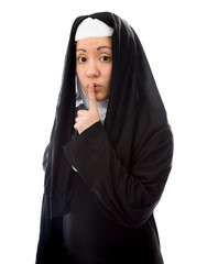 Young nun with finger on lips
