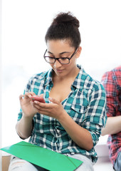 african student browsing in smartphone at school