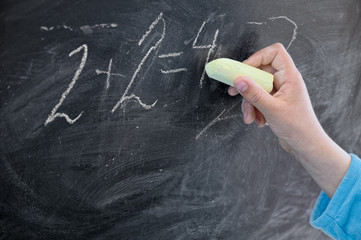 Blackboard, child hand and chalk. Maths education.