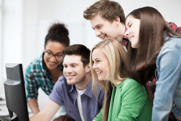 students looking at computer monitor at school