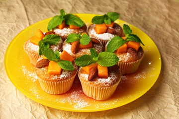 Tasty pumpkin muffins on brown paper