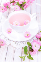 Beautiful fruit blossom with cup of tea on table close-up