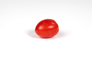 Closeup picture of a small tomato with some water droplets
