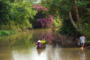 Fototapeta na wymiar women and children on rowboat with flower forTet in springtime