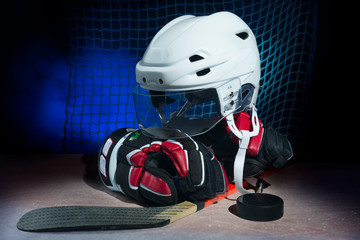 Hockey gloves,helmet and stick lay on ice.