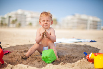 niño juega en la arena en la playa