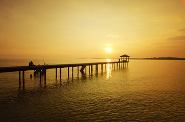 Fototapeta na wymiar a man sitting on the bridge alone during sunset