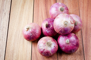 Red onions on the wood background